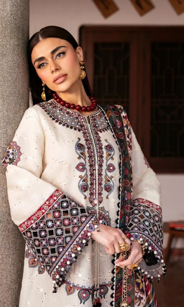 Model wearing a Jazmin Shahkaar cream-colored premium luxury lawn 3-piece suit featuring dark maroon and purple traditional geometric embroidery on wide-sleeves and pants, paired with a patterned multi-color digital print dupatta