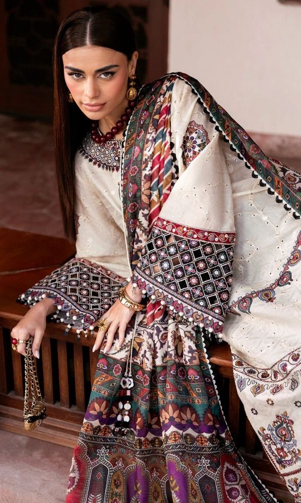 Model wearing a Jazmin Shahkaar cream-colored premium luxury lawn 3-piece suit featuring dark maroon and purple traditional geometric embroidery on wide-sleeves and pants, paired with a patterned multi-color digital print dupatta