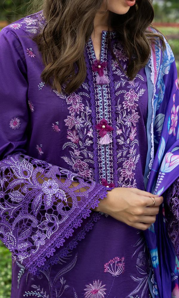 Person wearing a purple embroidered outfit with a matching scarf.
